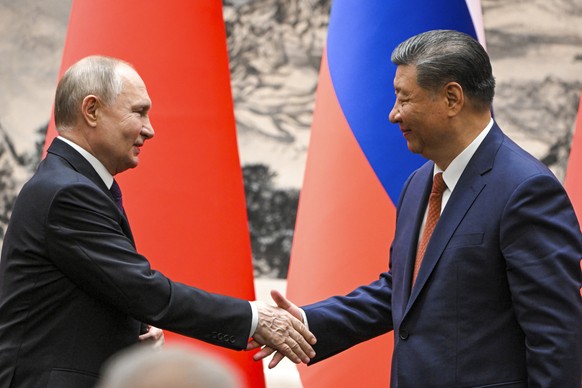 Chinese President Xi Jinping, right, shakes hands with Russian President Vladimir Putin at the Great Hall of the People, in Beijing, China, on Thursday, May 16, 2024. (Sergei Guneyev, Sputnik, Kremlin ...