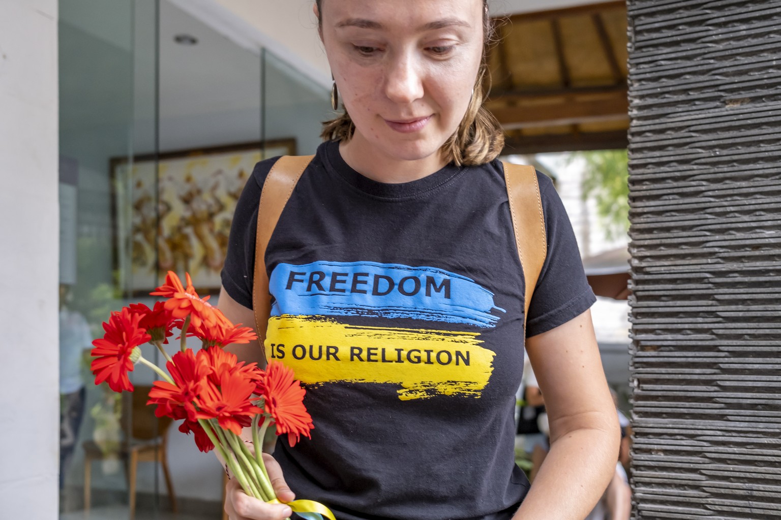 epa10487426 A woman holds flowers during a vigil for Ukraine in Denpasar, Bali, February 24, 2023. Ukrainians in Bali celebrated the first anniversary of the Russian invasion of Ukraine with a vigil outside ...