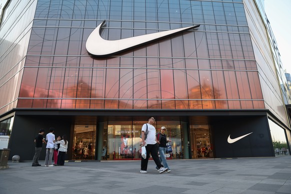 epa12099295 People walk past a Nike store in Beijing, China, 14 May 2025. After a tariff truce between the U.S. and China was agreed upon on 12 May, the U.S. will lower its maximum tariff rate on Chin ...