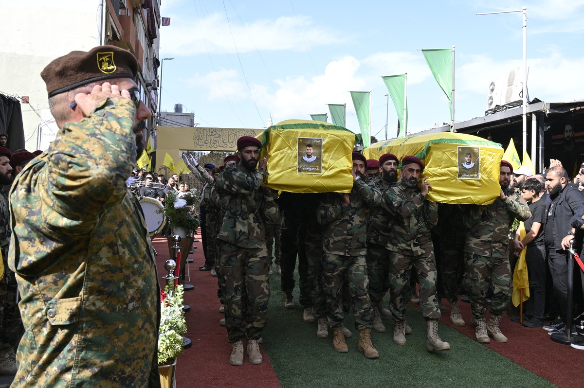 epa11613951 Hezbollah fighters carry the coffins of two people who died in communication devices blasts, during the funeral procession in Beirut, Lebanon, 19 September 2024. Lebanon's Health Mini ...