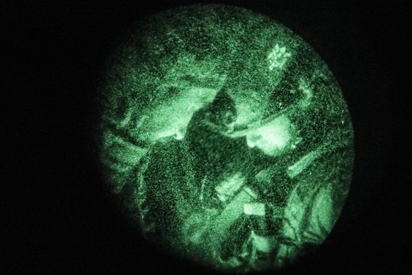 epa10639941 A picture taken through a night-vision device of Ukrainian servicemen from the 24th Mechanized Brigade &#039;King Danylo&#039; at an undisclosed location in the Donetsk region, eastern Ukr ...