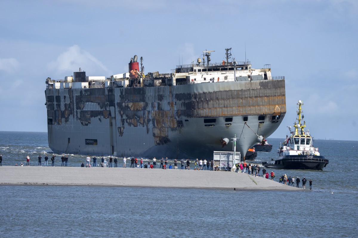 Stricken cargo ship Fremantle Highway, that caught fire while transporting thousands of cars, including nearly 500 electric vehicles, from Germany to Singapore, is towed into the port of Eemshaven, th ...