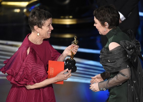 Frances McDormand, left, presents Olivia Colman with the award for best performance by an actress in a leading role for &quot;The Favourite&quot; at the Oscars on Sunday, Feb. 24, 2019, at the Dolby T ...