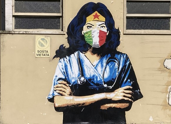 A Wonder Woman medic wearing a face mask with the colors of the Italian flag is painted on a wall in Codogno, the northern Italian town that recorded Italy&#039;s first locally spread coronavirus infe ...