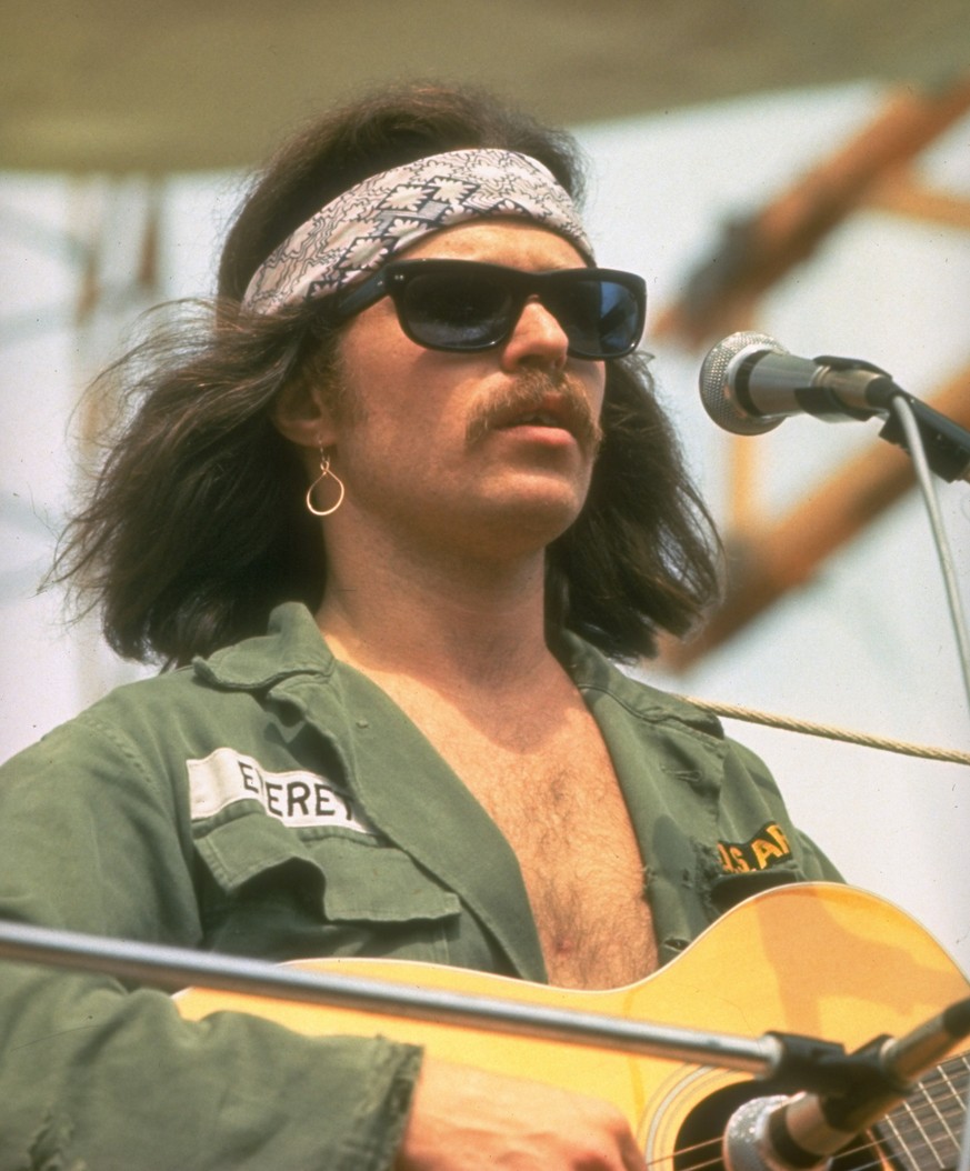 Folksinger Country Joe McDonald playing guitar while performing on stage during the Woodstock music festival. (Photo by Jason Laure/Woodfin Camp/Woodfin Camp/The LIFE Images Collection via Getty Image ...