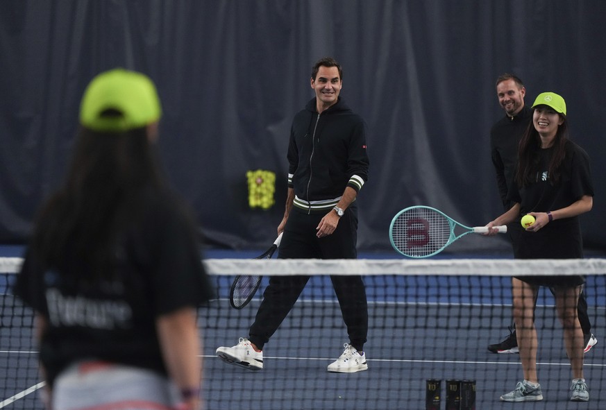 Retired tennis player Roger Federer, back left, participates in a tennis clinic for kids from the Vancouver chapters of Big Brothers and Big Sisters, as part of a partnership with Mercedes-Benz Canada ...