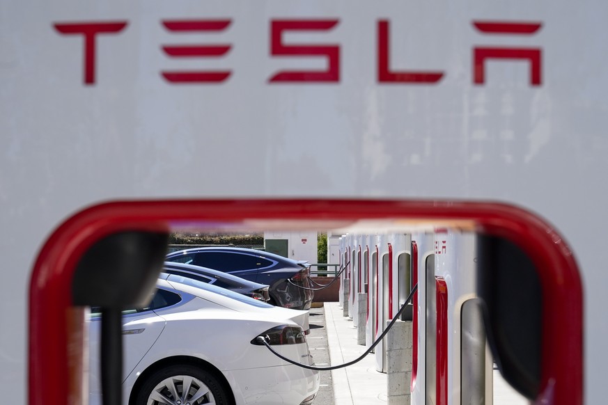 File - Tesla vehicles charge at a station in Emeryville, Calif., Wednesday, Aug. 10, 2022. Tesla released details of its quarterly financial performance Wednesday in a challenging environment, with in ...