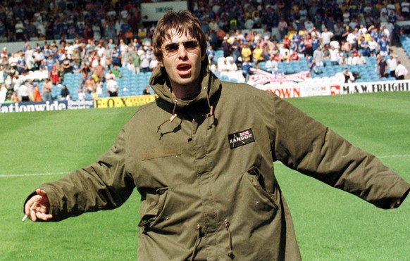 Liam Gallagher, frontman of British rock band Oasis, fools around on the field prior to the Premier League soccer match between Manchester City and Portsmouth on August 9, 1997, at Maine Road in Manch ...