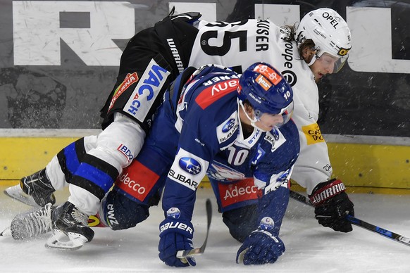 Der Zuercher Jerome Bachofner, links, gegen Andrea Glauser, rechts, von Fribourg beim Eishockeyspiel der National League ZSC Lions gegen den HC Fribourg Gotteron im Hallenstadion in Zuerich am Samstag ...