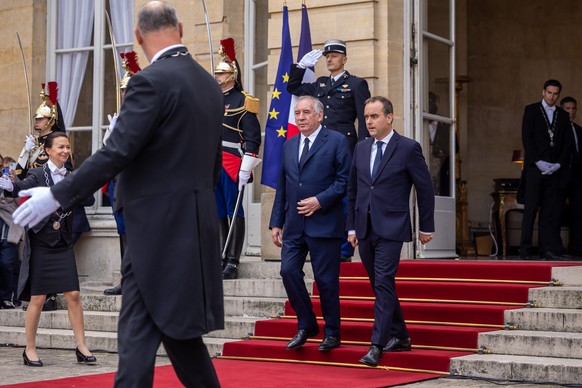 epa12367145 France&#039;s newly appointed Prime Minister Sebastien Lecornu (C-R) escorts France&#039;s outgoing Prime Minister Francois Bayrou (C-L) at the end of the handover ceremony at the Hotel Ma ...