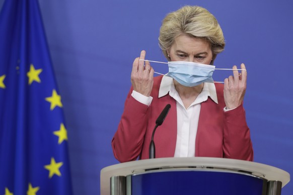 European Commission President Ursula von der Leyen takes off her protective face mask as she prepares to deliver a statement at EU headquarters in Brussels, Tuesday, July 27, 2021. The European Union  ...