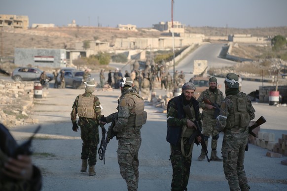 epaselect epa11750158 Opposition fighters patrol the streets after they took control of the city of Maarat al-Numan where the international road M5 passes through it, in Maarat al-Numan, Syria, 30 Nov ...