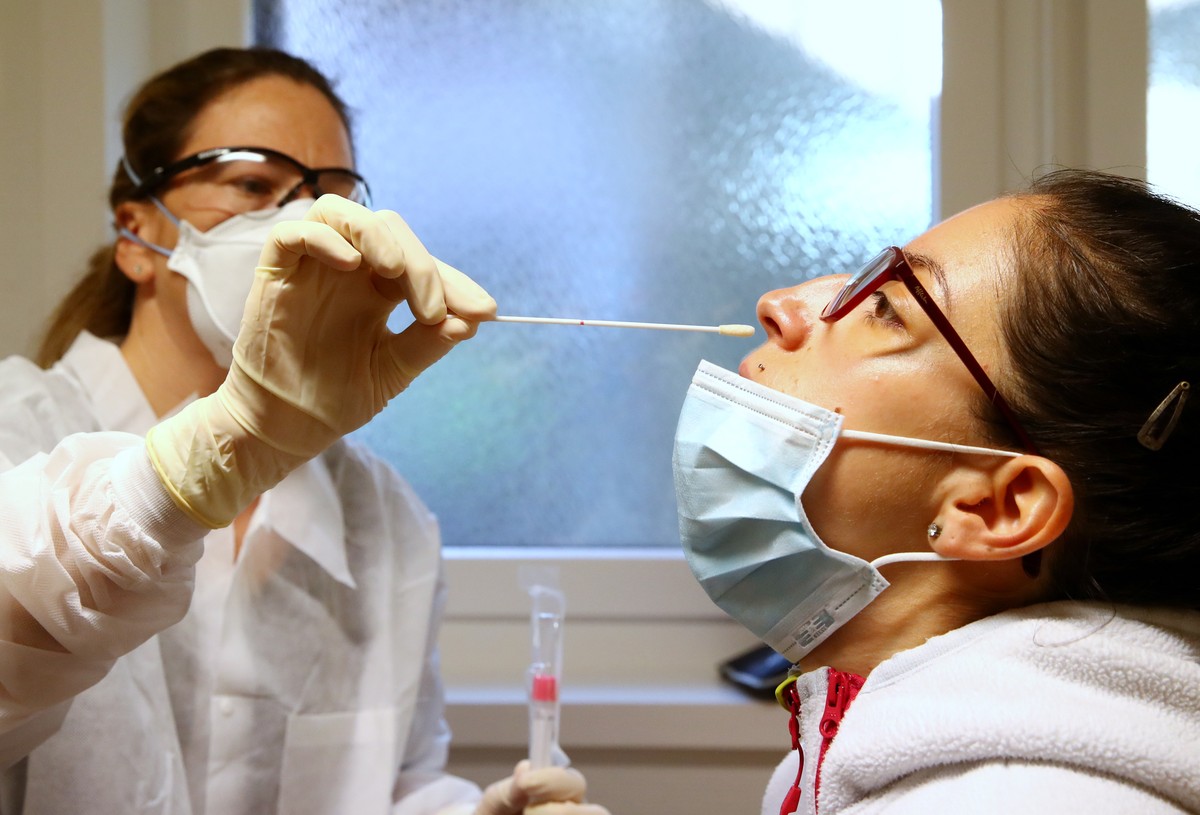 epa08340568 The physician Florence Joye takes a swab from a colleague, who was exposed to a family member who tested positive to coronavirus, during a media presentation of the safety checks, in her o ...