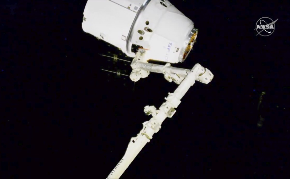 In this image taken from NASA video, NASA astronauts Andrew Morgan and Jessica Meir use the International Space Station's robot arm to capture the Dragon capsule Monday, March 9, 2020. The Dragon ...