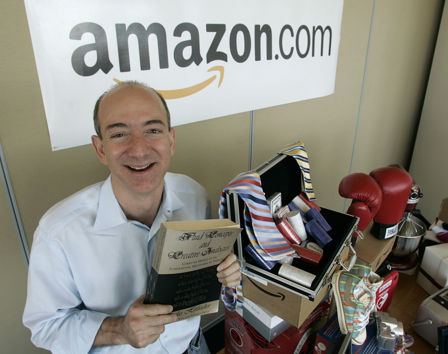 Amazon.com founder and CEO Jeff Bezos holds a copy of &quot;Fluid Concepts and Creative Analogies&quot; by Douglas Hofstadter -- the first book sold on-line by Amazon.com -- as he stands Friday, June  ...