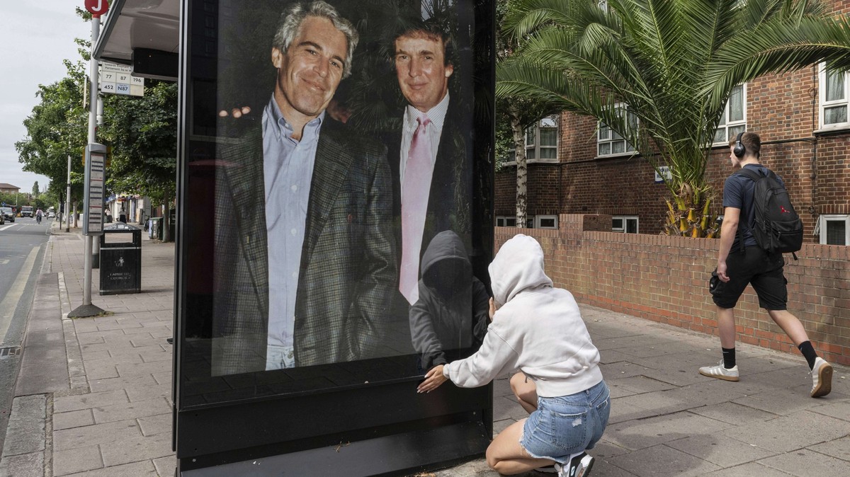 Activists put up a poster showing President Donald Trump and Jeffrey Epstein near the U.S. Embassy in London, Thursday, July 17, 2025.(AP Photo/Thomas Krych)
