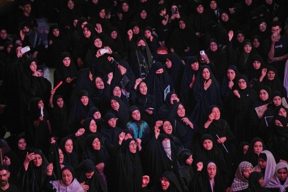 Mourners chant and raise their hands as the funeral procession of the late Iranian Supreme Leader Ayatollah Ali Khamenei passes outside the Imam Hussein Shrine in Karbala, Iraq, early Thursday, July 9 ...