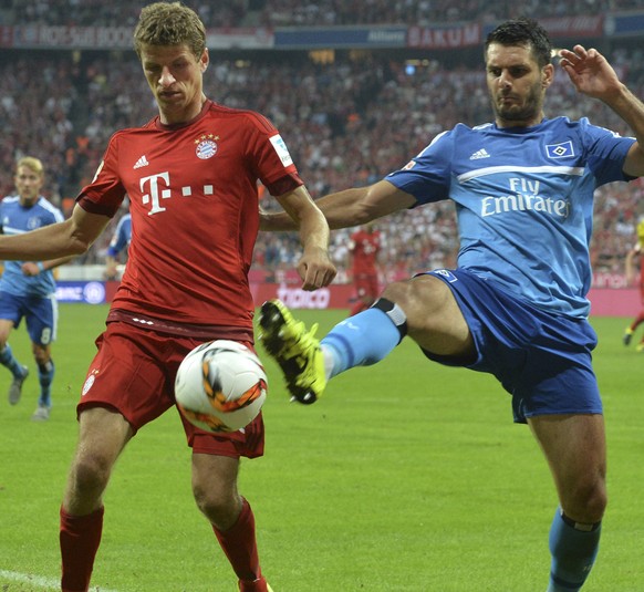 Hamburg&#039;s Emir Spahic, right, challenges Bayern&#039;s Thomas Mueller during the German Bundesliga soccer match between FC Bayern Munich and Hamburger SV in Munich, southern Germany, Friday, Aug. ...