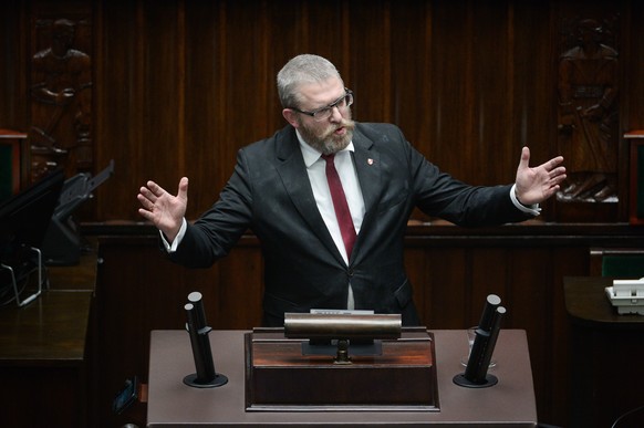 epa11024750 Member of Parliament Grzegorz Braun, of the far-right Confederation party, speaks after extinguishing the Hanukkah candles with a fire extinguisher at the Polish parliament building in War ...