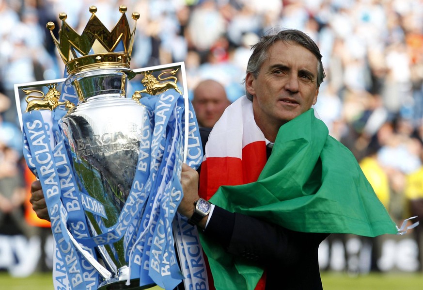 Manchesteter City Moments File photo dated 13-05-2012 of Manchester City manager Roberto Mancini celebrates with the trophy. Roberto Mancini s City clinched the title, but only at the end of a roller- ...