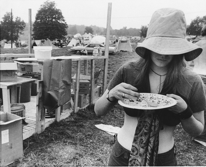 **ADVANCE FOR MONDAY AUG. 10** FILE - In this August 1969 file photo, a woman helps herself to a free food ration in the camp area at the Woodstock Music Festival in Bethel, N.Y. on Aug. 15, 1969. (AP ...