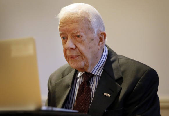 FILE - In a Tuesday, Feb. 2, 2016 file photo, former US President Jimmy Carter listens during a video interview with the Associated Press via a laptop at a hotel in London. Carter said Monday, June 20 ...