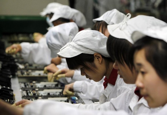 FILE - In this May 26, 2010 file photo, staff members work on the production line at the Foxconn complex in the southern Chinese city of Shenzhen, southern China. A pledge reported Thursday, March 29, ...