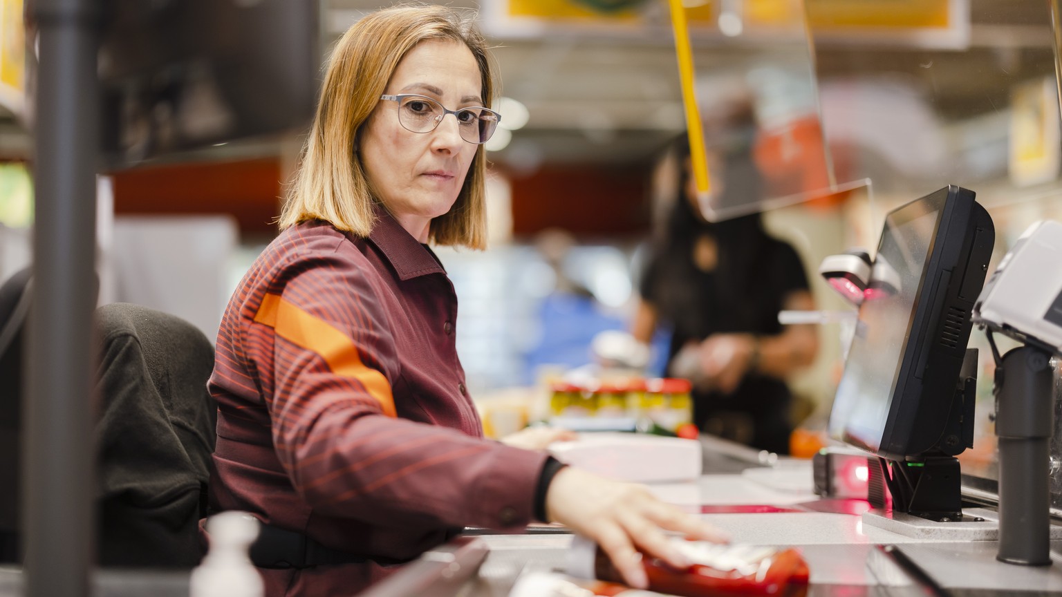 Die Verkaeuferin Stefania Kaufmann bedient eine Kundin bei ihrem Einkauf in der Migros am Limmatplatz, am Donnerstag, 17. Februar 2022 in Zuerich. Der Bundesrat hebt per Donnerstag fast alle Corona-Ma ...