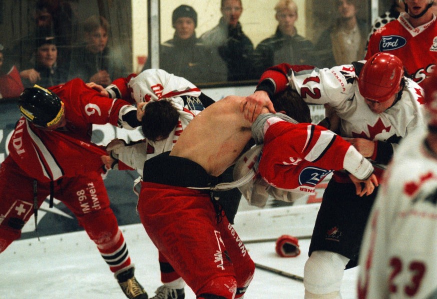 Fighting and wrestling-scene between unidentified Canadian (white) and Swiss hockey players during the match Switzerland vs. Team Canada in Huttwil, Switzerland, February 12, 1998. (KEYSTONE/JUERG MUE ...