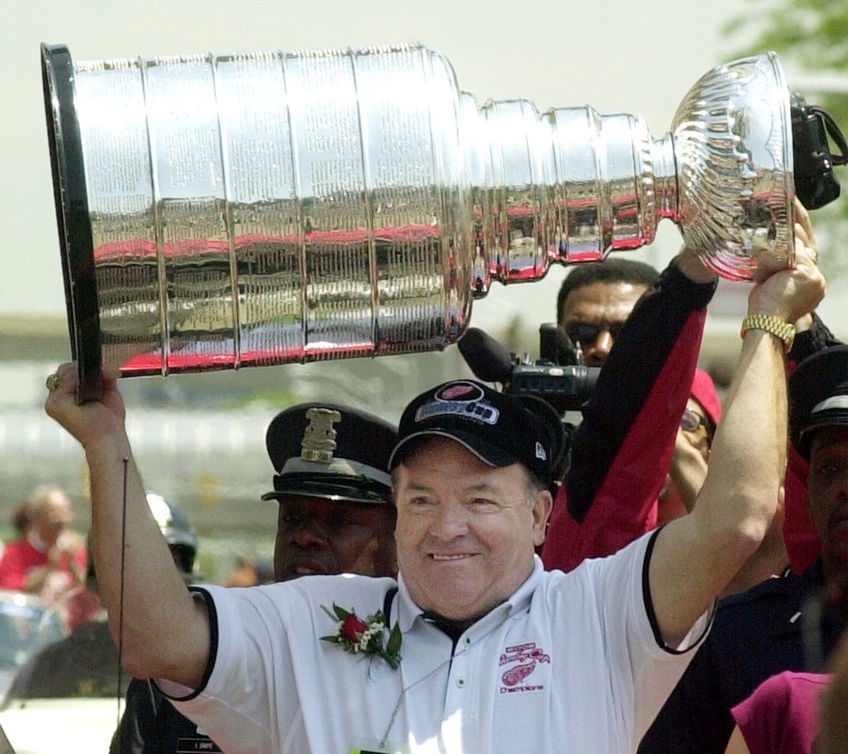 Detroit Red Wings former head coach Scotty Bowman lifts the Stanley Cup during the team's victory parade on Monday, June 17, 2002 in Detroit. The Red Wings beat the Carolina Hurricanes to win the ...