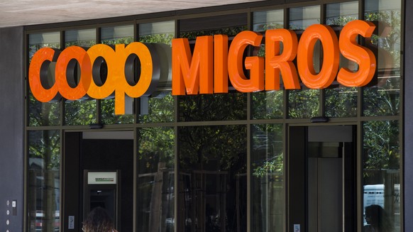 Le logo de la Coop et le logo de la Migros sont photographies cote a cote sur un batiment commercial commun ce mardi 23 aout 2016 sur la place de la Sallaz a Lausanne. (KEYSTONE/Jean-Christophe Bott)