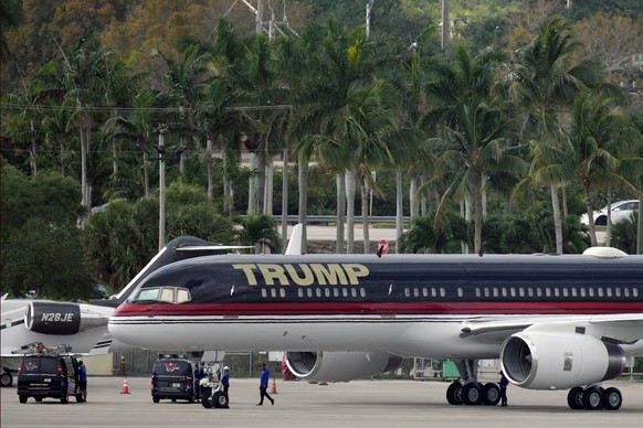People work around the private plane of former president Donald Trump as it sits parked on the tarmac at Palm Beach International Airport, Monday, April 3, 2023, in West Palm Beach, Fla. Trump was exp ...