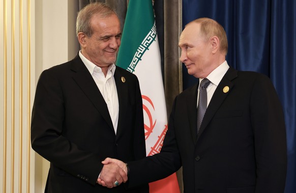 epa12343525 Iranian President Masoud Pezeshkian (L) and Russian President Vladimir Putin (R) pose for photos before a meeting on the sidelines of the Shanghai Cooperation Organisation (SCO) summit in  ...