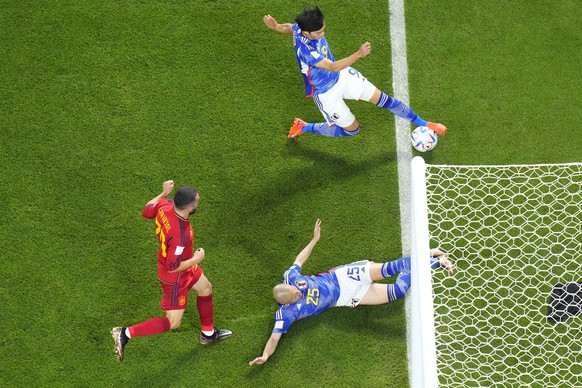 Japan&#039;s Kaoru Mitoma appears to have the ball over the line before crossing it for a goal during the World Cup group E soccer match between Japan and Spain, at the Khalifa International Stadium i ...