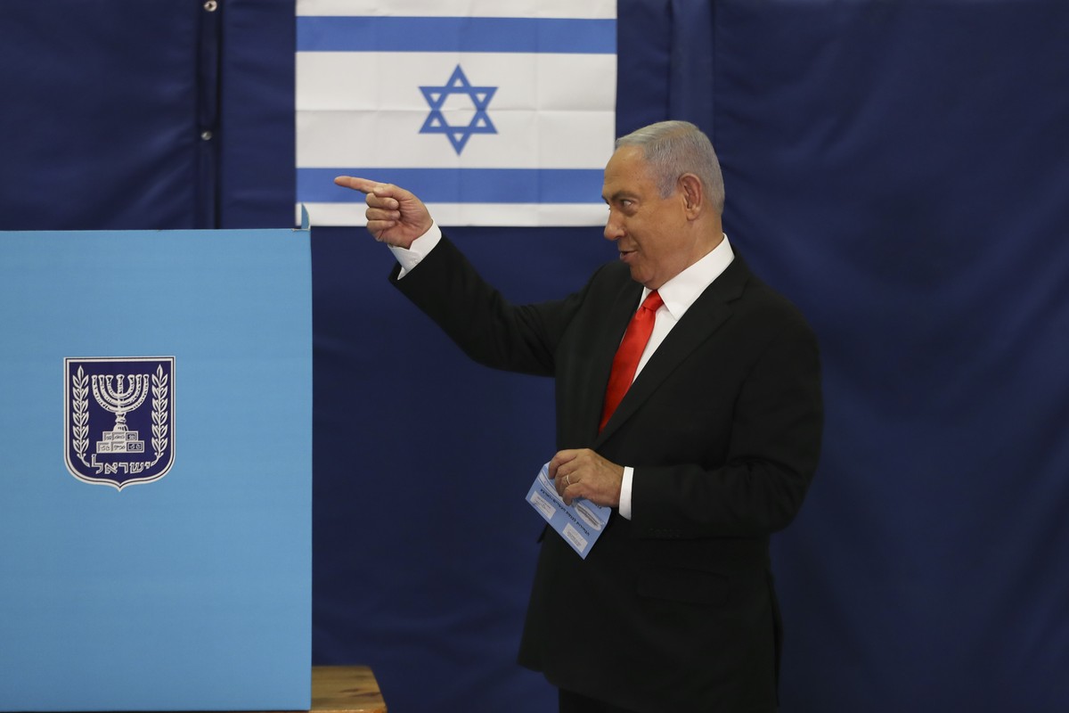 Israeli Prime Minister Benjamin Netanyahu prepares to cast his ballot at a polling station as Israelis vote in a general election, in Jerusalem, Tuesday, March 23, 2021. Israelis began voting on Tuesd ...