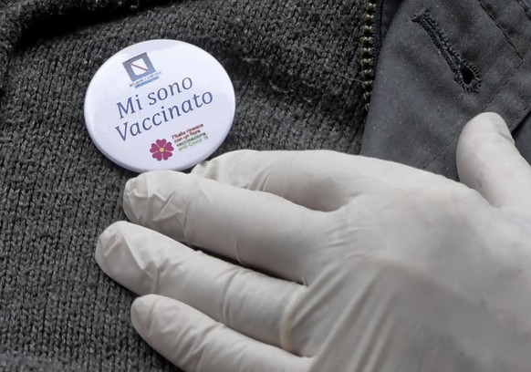 epa09101030 A close up shows a pin reading in Italian &quot; I am vaccinated&quot; after he received his COVID-19 vaccine at the Madre Museum in Naples, Italy, 27 March 2021. A new COVID-19 vaccinatio ...