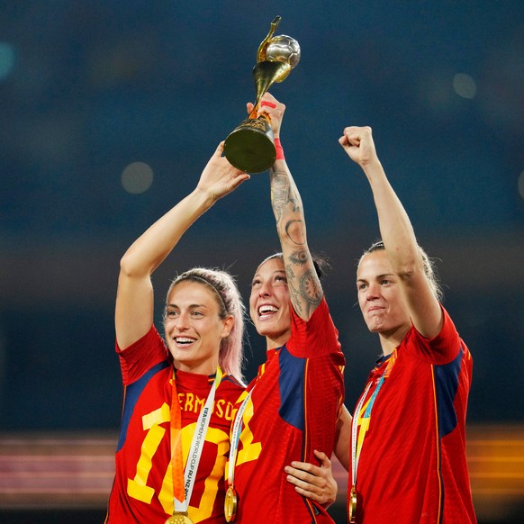FILE - Spain's Alexia Putellas, Jennifer Hermoso and Irene Paredes ,from left, celebrate with the trophy at the end of the Women's World Cup soccer final between Spain and England at Stadium ...