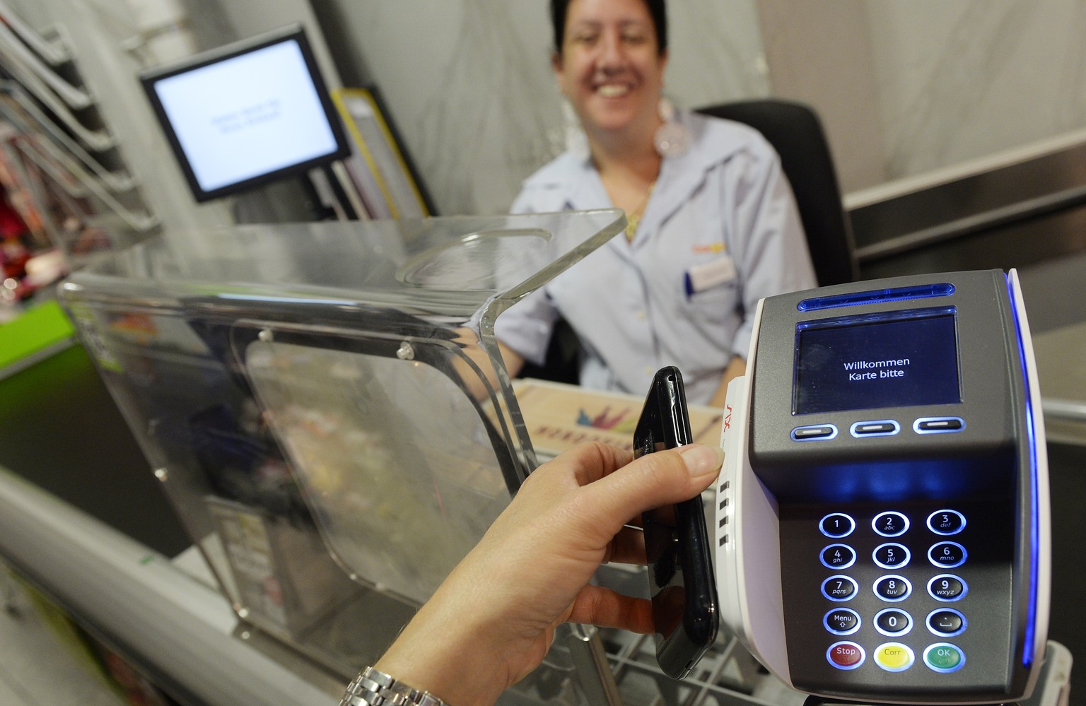 Eine Frau bezahlt mit dem Smartphone an der Kasse einer Coop Filiale in Zuerich am Dienstag, 1. Juli 2014. Mit &quot;Tapit&quot; kommt erstmals eine Smartphone App auf den Schweizer Markt, die das Bez ...