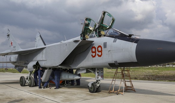 epa09760105 A handout image made available by the Russian Defence Ministry press service shows Russian servicemen prepare for fly a MiG-31 fighter of the Russian Airspace forces on Hmeimim (also Khmei ...