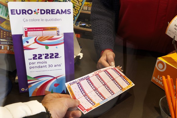 Un membre de la loterie romande presente le nouveau jeu de la loterie romande EURODRAMS a Josephine, kiosquiere, avant son lancement, ce lundi 16 octobre 2023 a Cheseaux-sur-Lausanne pres de Lausanne. ...