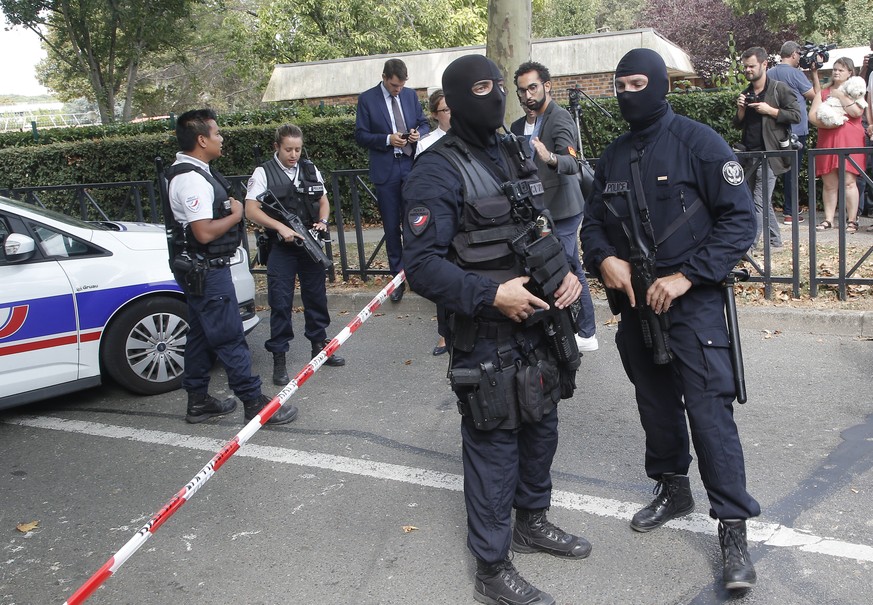 French hooded police officers cordon off the area after a knife attack Thursday, Aug. 23, 2018 in Trappes, west of Paris. A man flagged by French authorities as a suspected radical killed his mother a ...