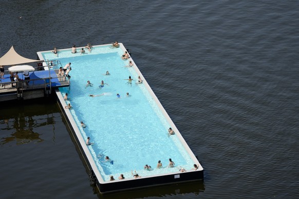 People enjoy a hot summer day at the so called Badeschiff, Bathing Ship, pool in Berlin, Germany, Tuesday, July 19, 2022. A heat wave with temeratures over 38 degrees celsius are expected for parts of ...