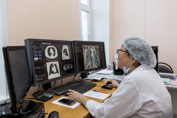 A medical worker looks at a computer tomography examination of patients suspected of having coronavirus at the hospital in Ulan-Ude, the regional capital of Buryatia, a region near the Russia-Mongolia ...