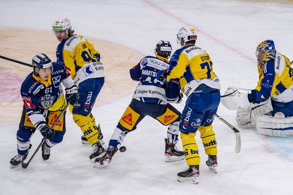 Sven Leuenberger, links, von Zug fim Spiel gegen Torhueter Robert Mayer, rechts, von Davos beim Eishockey Meisterschaftsspiel in der Qualifikation der National League zwischen dem EV Zug und dem HC Da ...