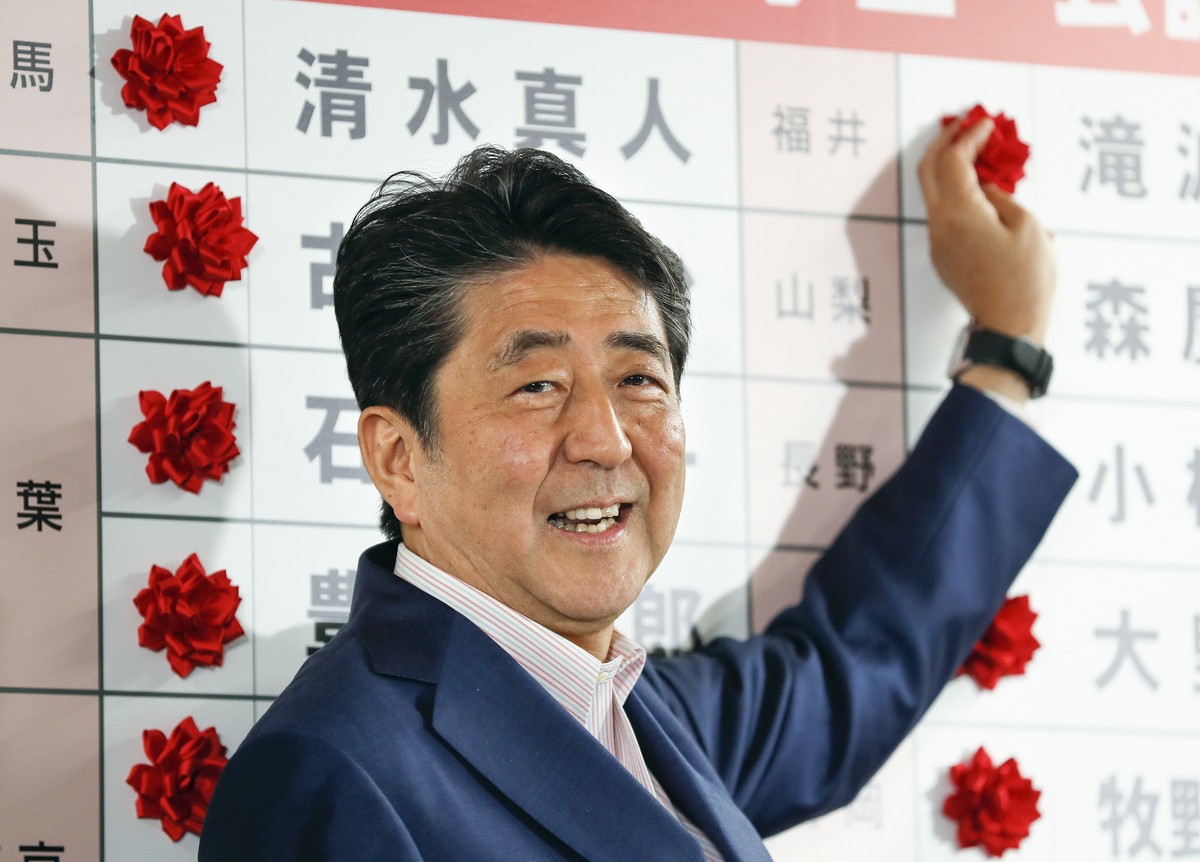 epa07731355 Japanese Prime Minister and the ruling Liberal Democratic Party (LDP) President, Shinzo Abe, puts red rose marks on the names of the party's victorious candidates in the Upper House e ...