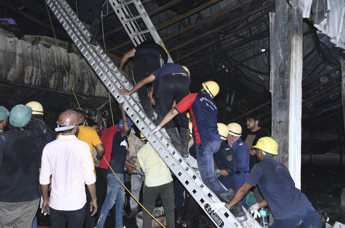 Firefighters and locals douse a fire which broke out in a fun park, in Rajkot in the Indian state of Gujarat, Saturday, May 25, 2024. A massive fire broke out on Saturday in a fun park in western Indi ...