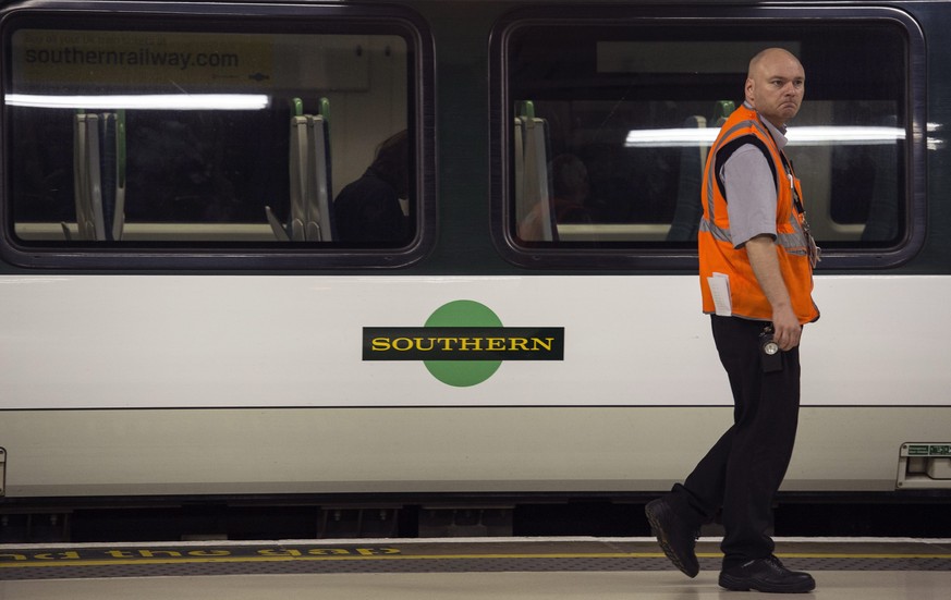 epa05464948 An employee walks past a Southern train during a strike by members of the RMT Union on the Southern rail franchise network, Victoria Station, Central London, Britain, 08 August 2016. The s ...