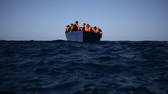 Migrants from Eritrea, Egypt, Syria and Sudan, wait to be assisted by aid workers of the Spanish NGO Open Arms, after fleeing Libya on board a precarious wooden boat in the Mediterranean sea, about 11 ...