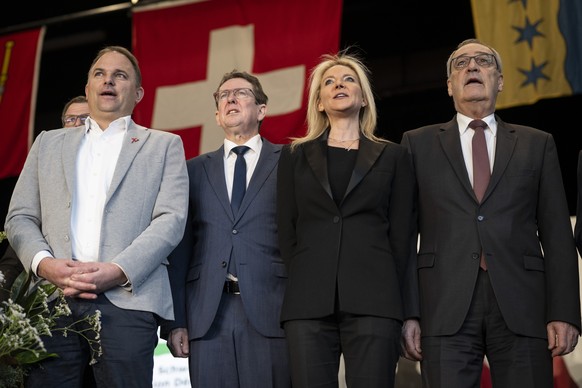 KEYPIX - Parteipraesident Marcel Dettling, Bundesrat Albert Roesti, Vize-Parteipraesidentin Celine Amaudruz, und Bundespraesident Guy Parmelin, von links, singen die Nationalhymne, an der Delegiertenv ...