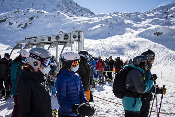 Skiers wearing face masks queue for the chairlift on the opening day of the Verbier ski area in the Swiss Alps during the coronavirus disease (COVID-19) outbreak, in Verbier, Switzerland, Friday, Octo ...